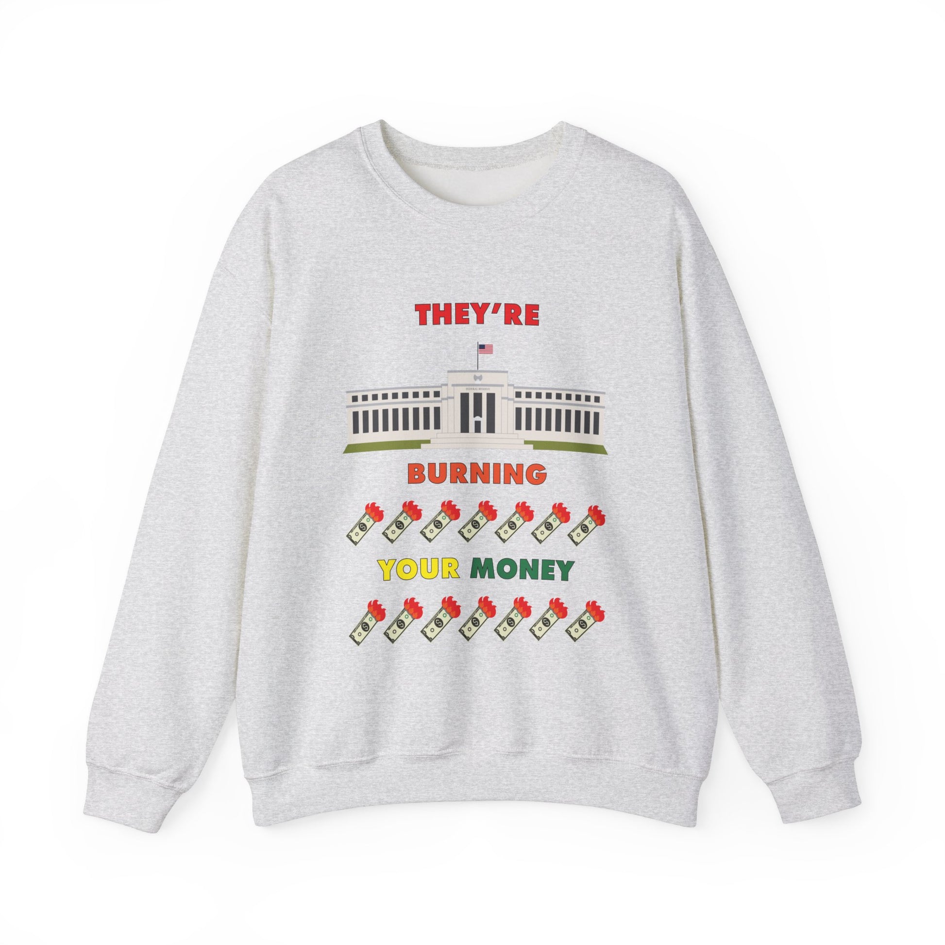 Light grey crewneck sweatshirt with the words "They're Burning Your Money" in large bold letters. The design has a digital drawing of the United States Federal reserve building in Washington D.C. and it features drawings of burning dollar bills.