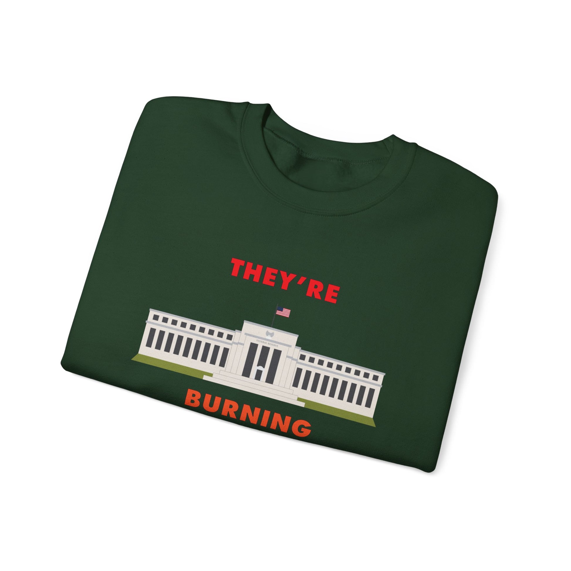 Folded green crewneck sweatshirt with the words "They're Burning" in large bold letters. The design has a digital drawing of the United States Federal reserve building in Washington D.C.